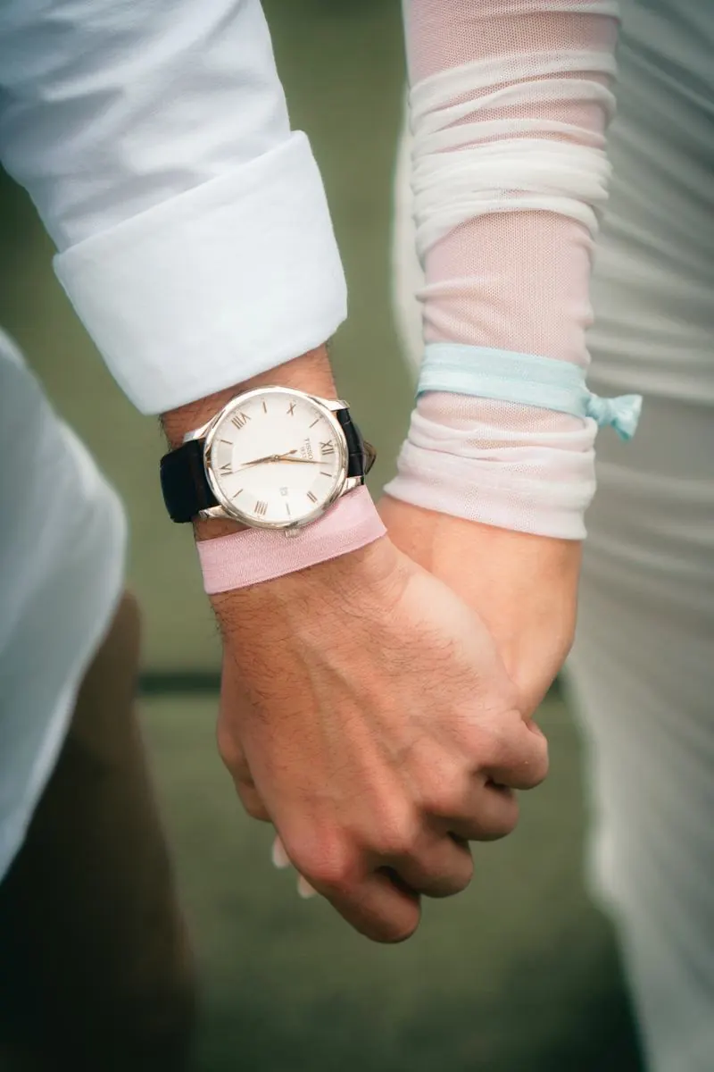 Manos de la pareja con cintas azul y rosa